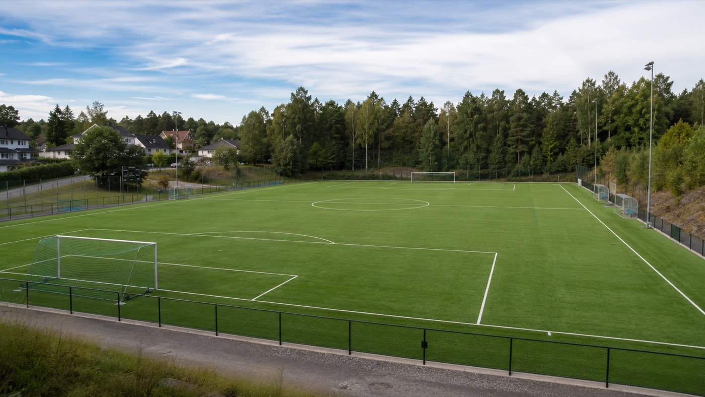 Fotbollsplan i Rönninge omgiven av skog och villor